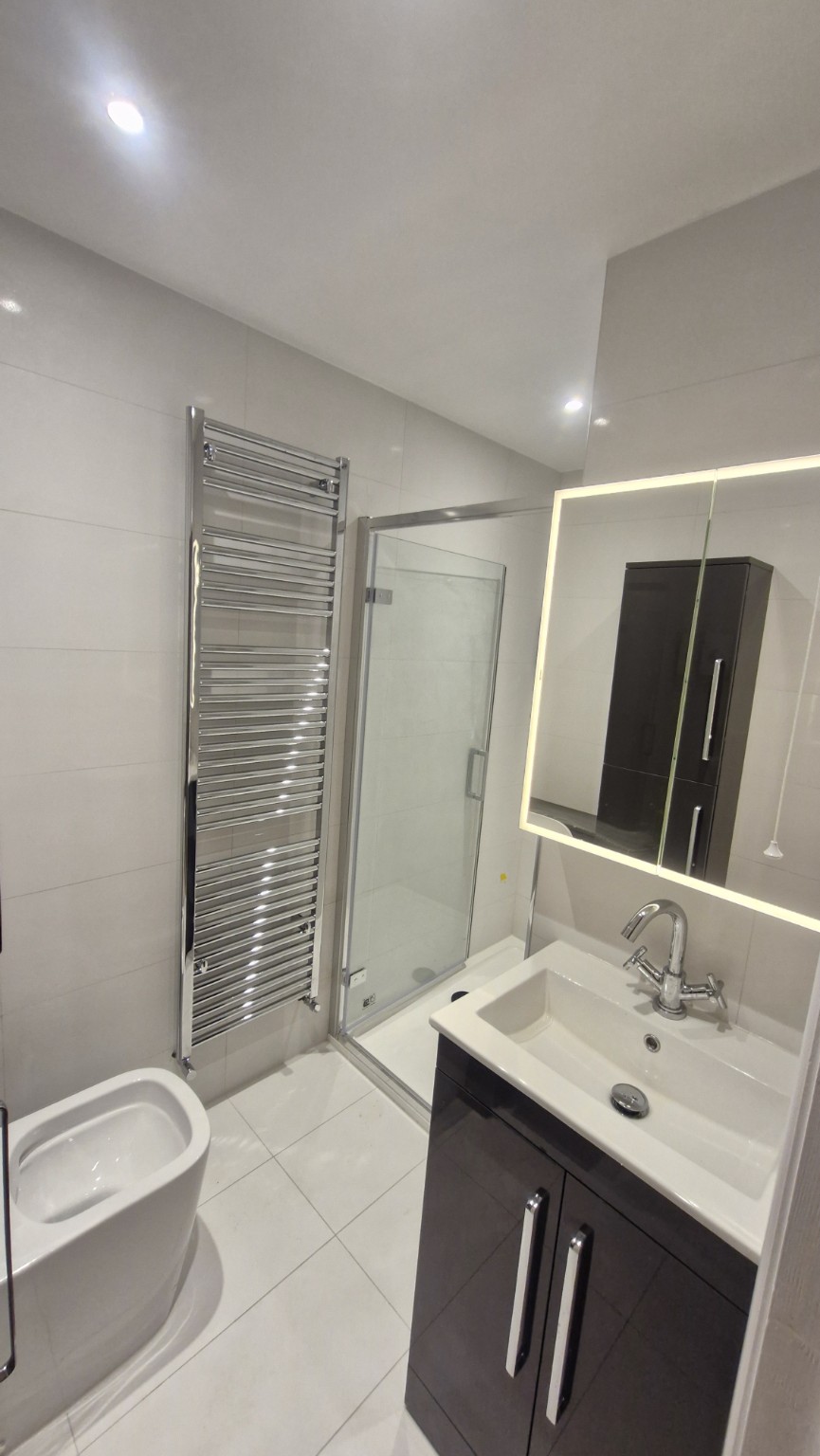 Completed bathroom with shower, vanity and illuminated mirror